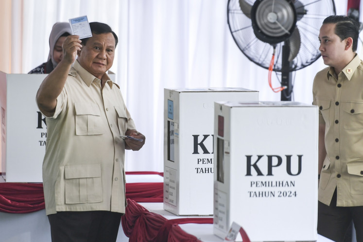 Presiden Prabowo Subianto (kiri) menunjukkan surat suaranya ke wartawan setelah memilih dalam Pilkada 2024 di TPS Bojong Koneng, Bogor, Jawa Barat, tanggal 27 November 2024. Negara sedang mengadakan pilkada serentak di 37 provinsi dan lebih dari 500 kota serta kabupaten.