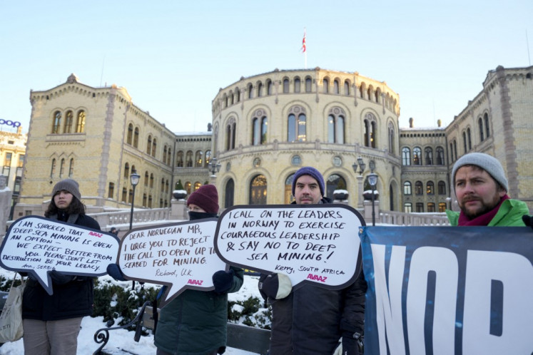 Pengunjuk rasa memegang plakat selama demo menentang penambangan dasar laut di luar gedung Parlemen Norwegia di Oslo, 9 Januari 2024. Parlemen Norwegia memberi suara pada 9 Januari 2024 untuk RUU tentang pembukaan sebagian dasar lautnya untuk penambangan, menuai protes dari aktivis lingkungan yang khawatir akan dampaknya.